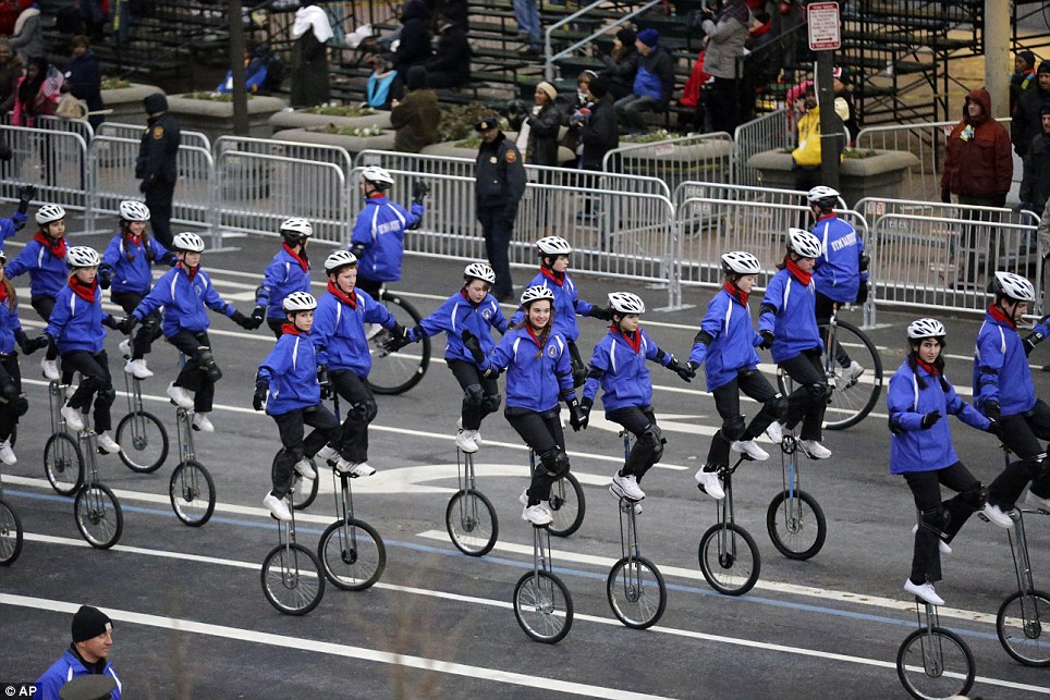 Close up pic of the Gym Dandies riding giraffe unicycles in the inaugural parade